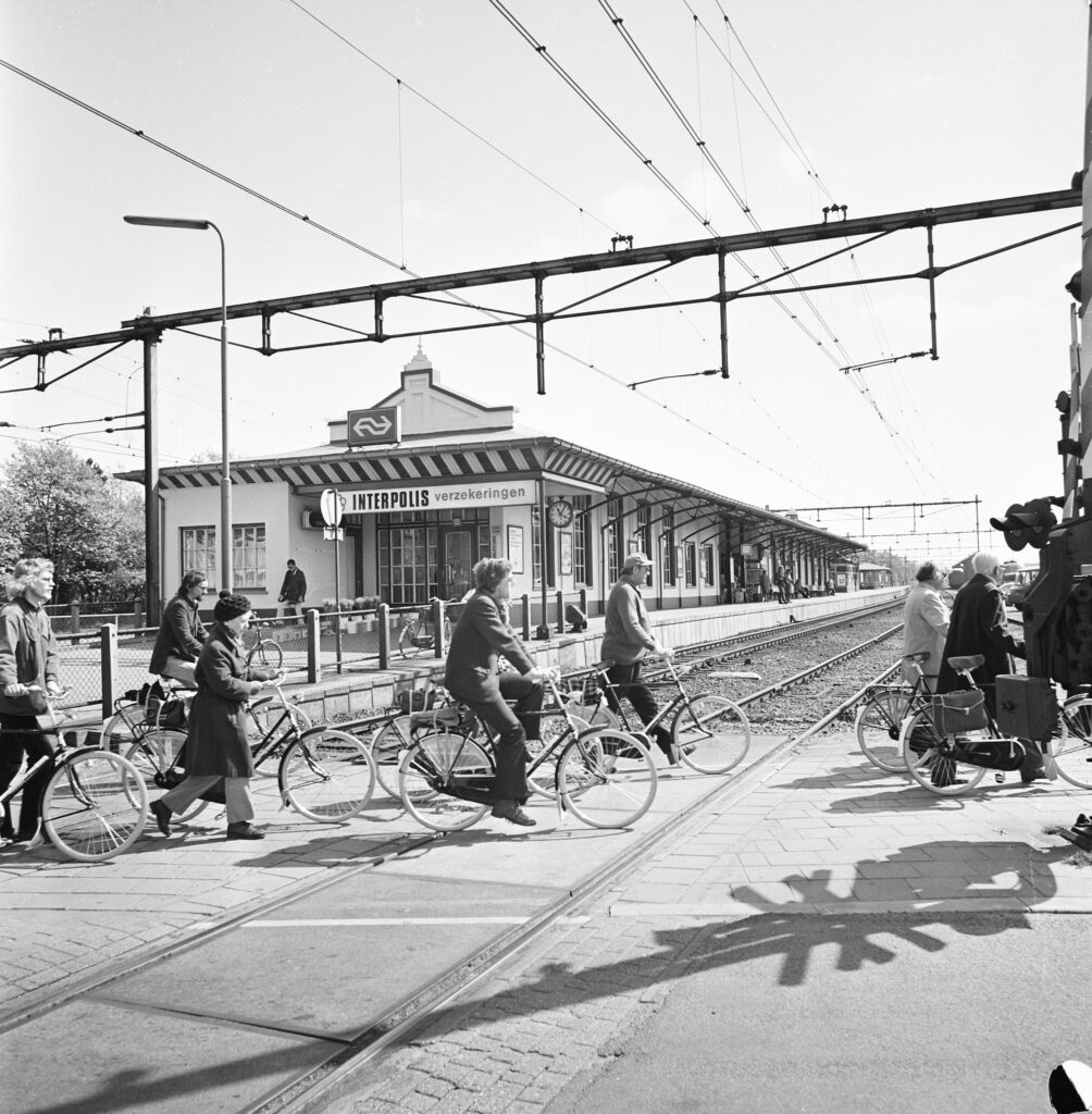 Fietsers bij de spoorwegovergang voor het oude station Ede-Wageningen in 1974