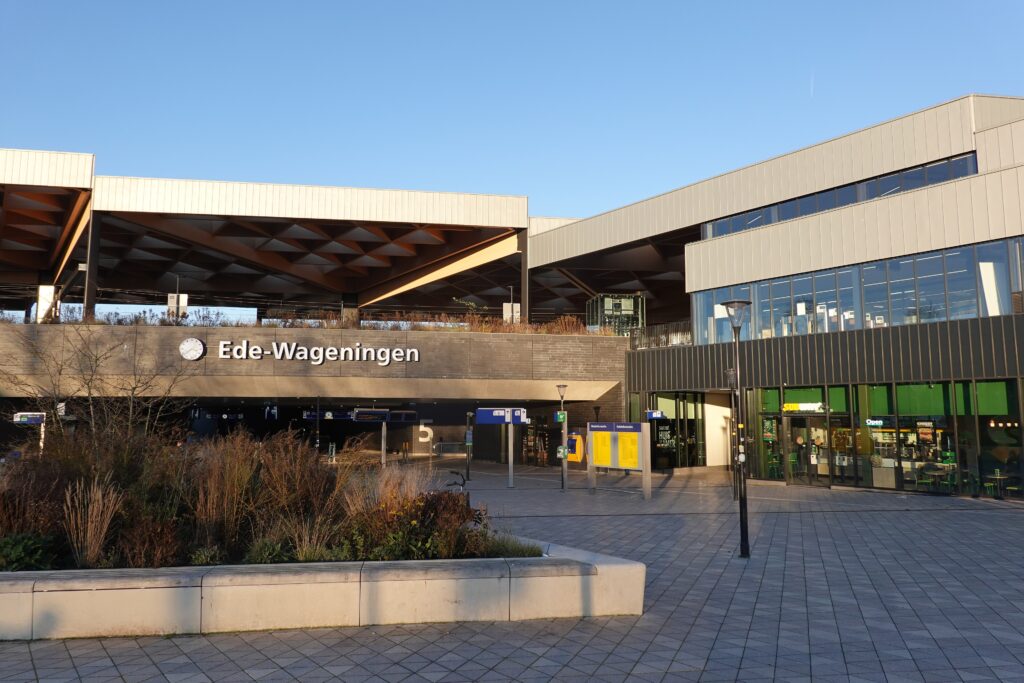 Het afgebouwde station Ede-Wageningen met voorplein in gouden avondlicht, december 2025